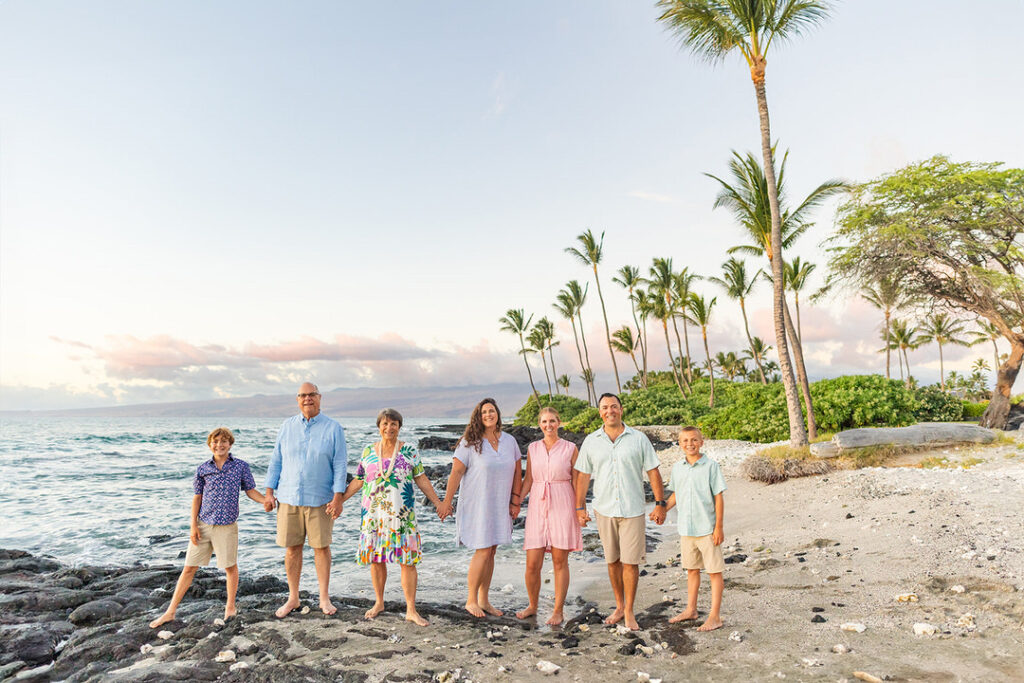 Family laughing together during a sunset beach photoshoot at Mauna Lani